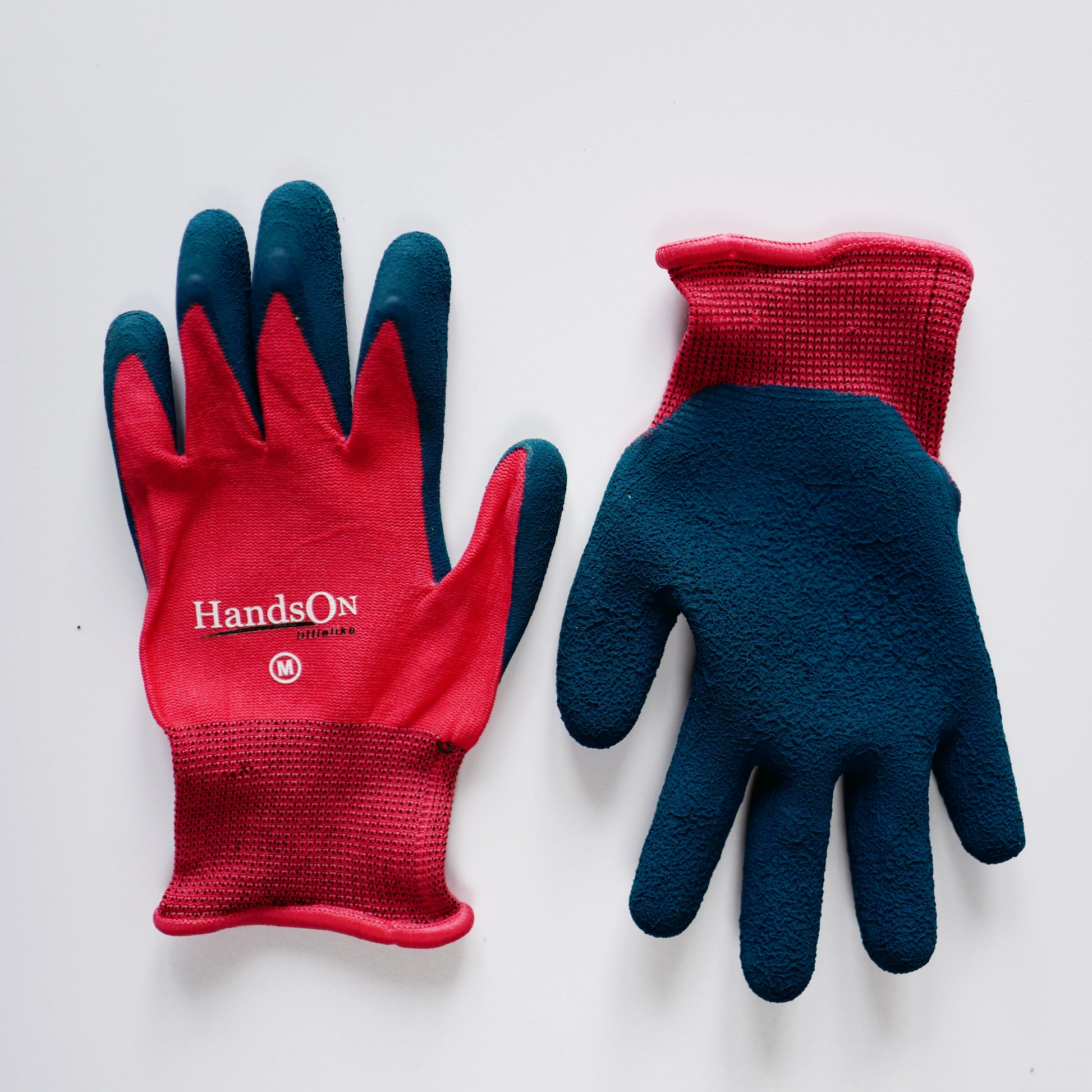 HandsOn™ Children’s gardening gloves with red knit backs, blue textured grip palms, elasticated cuffs, designed to protect kids’ hands during gardening and outdoor play.