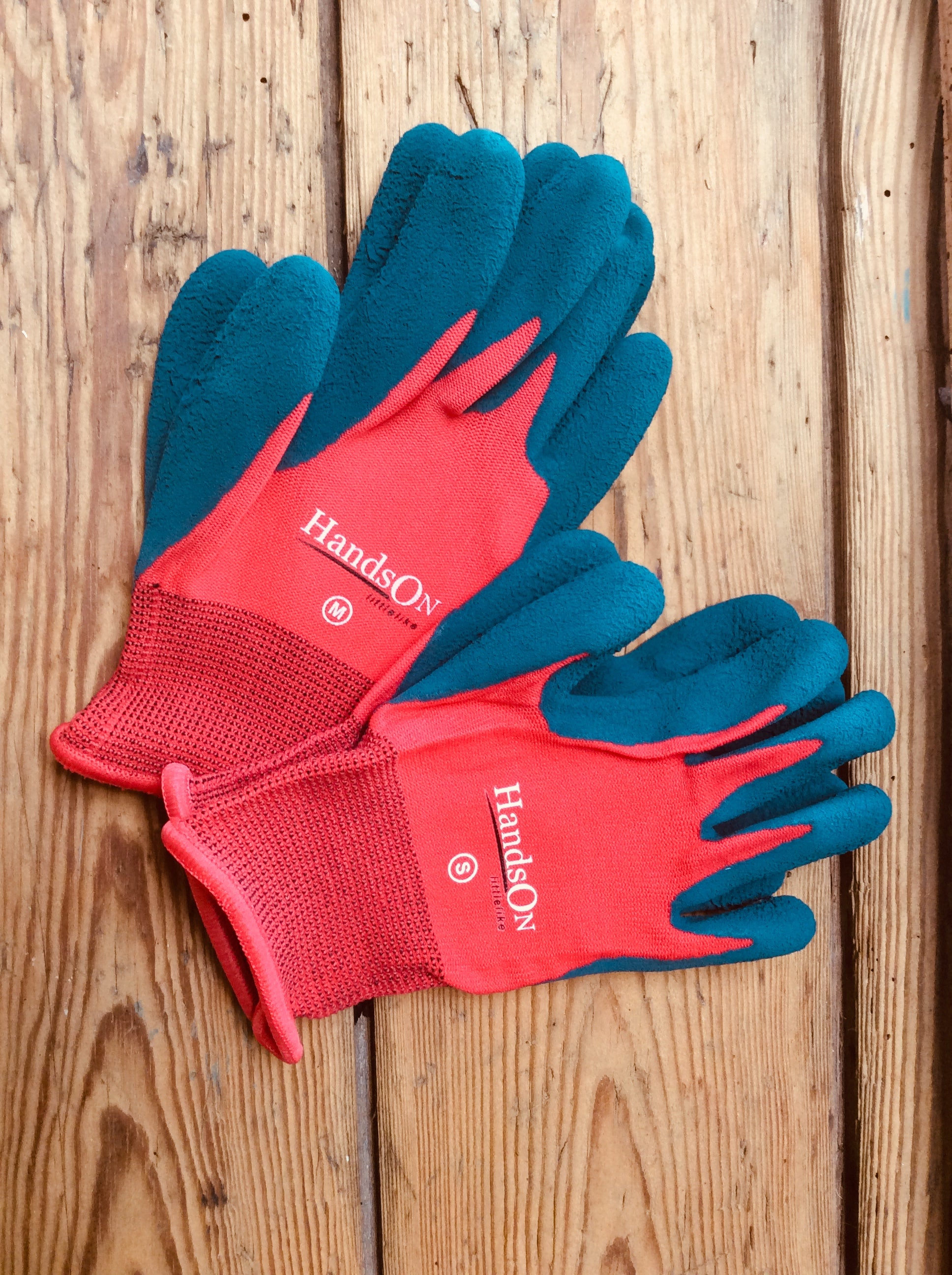 HandsOn™ Children’s gardening gloves with red knit backs, blue textured grip palms, elasticated cuffs, designed to protect kids’ hands during gardening and outdoor play.